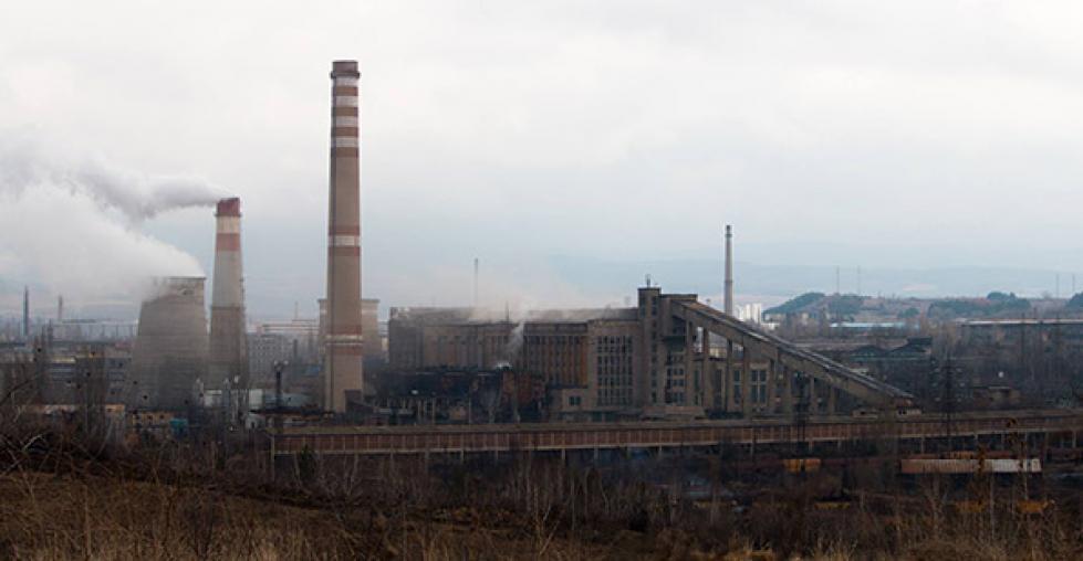 Image: Smokestacks in Pernik in front of a twon submerged in smog.
